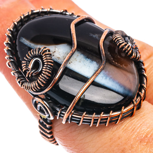 Oxidized copper wire wrap ring with black and blue banded agate stone, front view