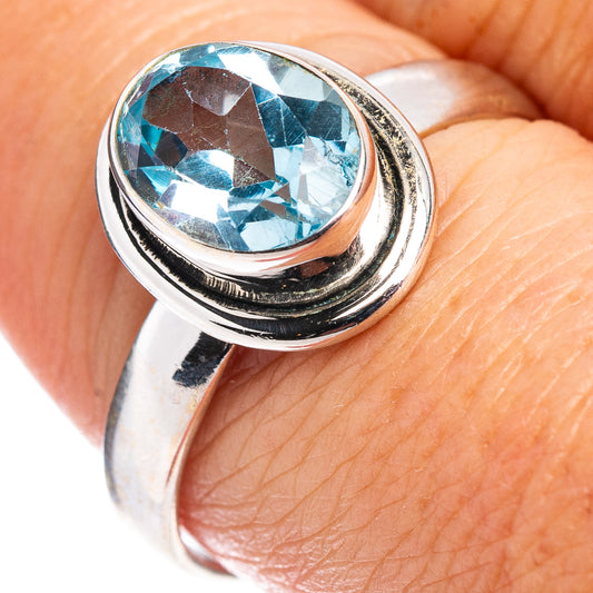 Sterling silver ring with faceted oval blue topaz centerpiece, size 8.25