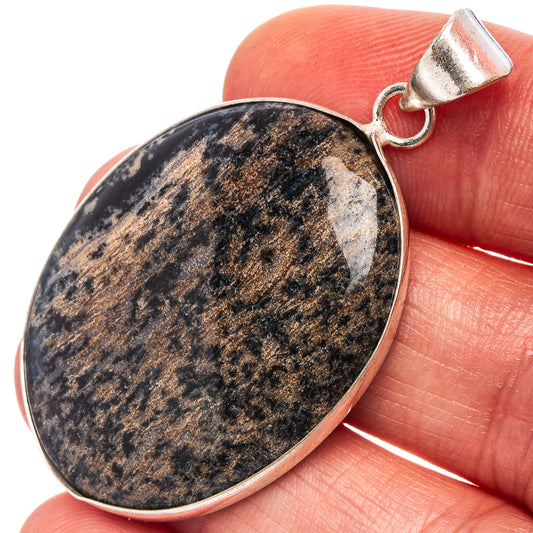 Silver-plated oval dendritic pendant with dark blue and white speckled stone, top bail