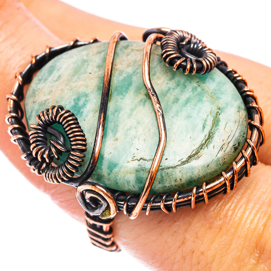 Oxidized copper wire wrap ring on finger, oval green amazonite center stone