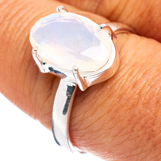 Sterling silver oval opal ring with prong-set pale opal on finger