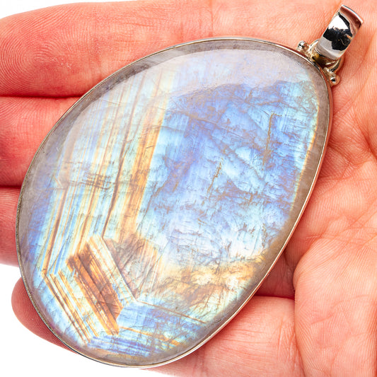 Oval rainbow moonstone pendant with blue, gold iridescent flashes in sterling silver bezel