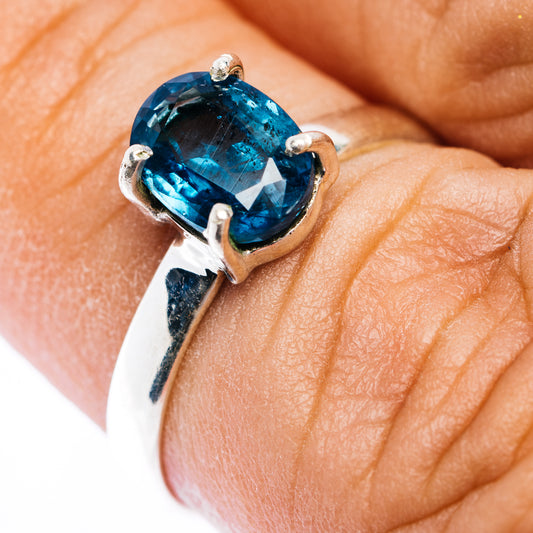 Sterling silver kyanite ring with oval faceted deep teal gemstone, four prong setting