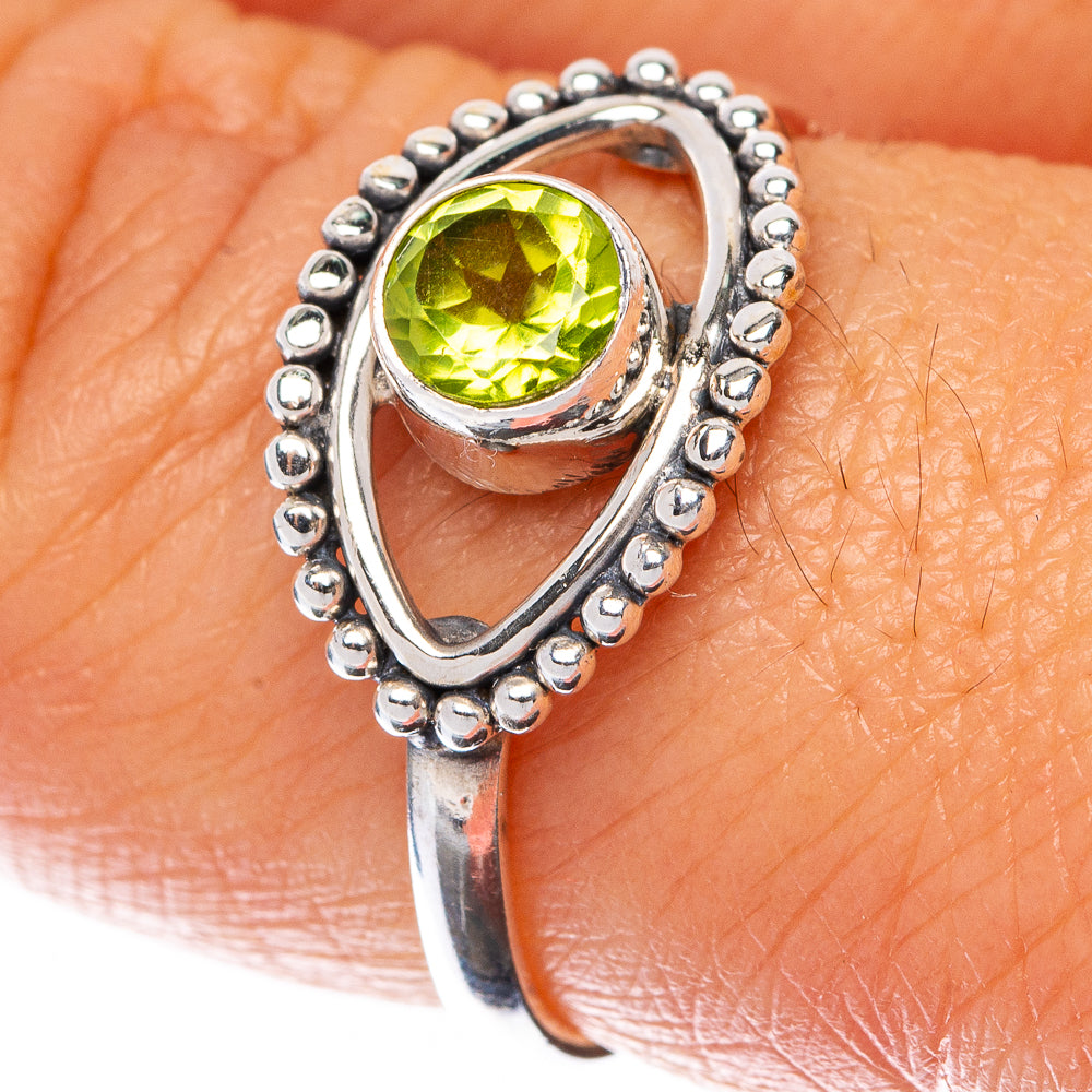 Sterling silver peridot ring with oval green gemstone and bead halo teardrop setting