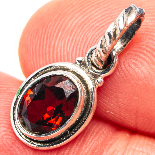 Oval garnet pendant in .925 sterling silver with red faceted gemstone, close-up
