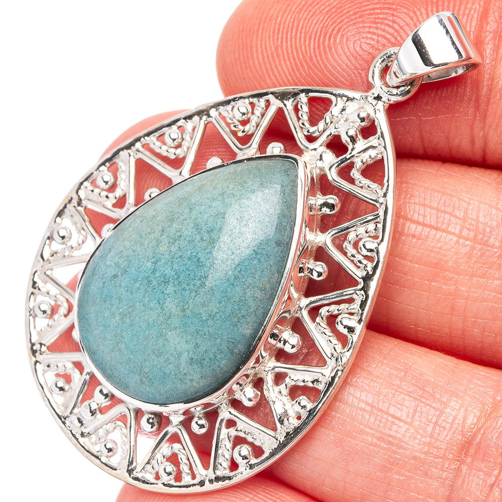 Teardrop sterling silver pendant with blue-green turquoise cabochon and ornate border