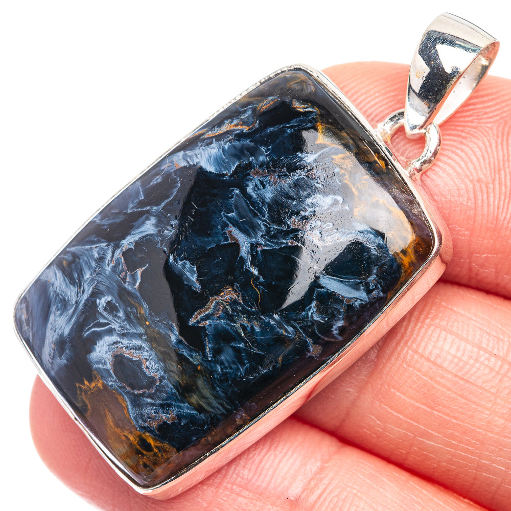 Rectangular pietersite pendant in silver bezel, close-up view with blue and orange swirls