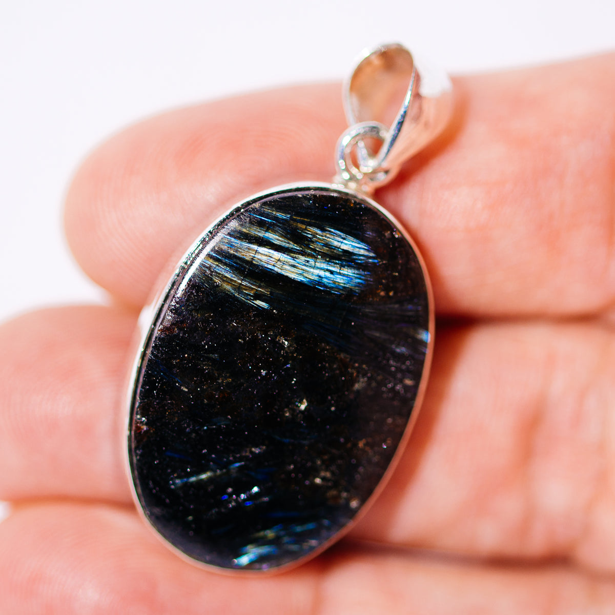 Arfvedsonite pendant with a dark oval stone in a sterling silver bezel and loop