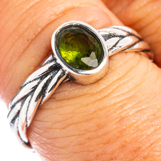 Sterling silver ring with oval green peridot gemstone in a bezel on a twisted band