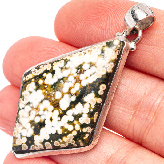 Ocean jasper pendant with black-and-gold mosaic stone and silver bail, close-up