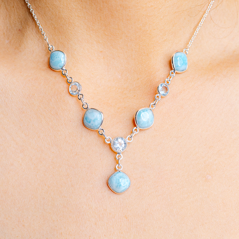 Sterling silver necklace with oval blue gemstones and small round clear accents