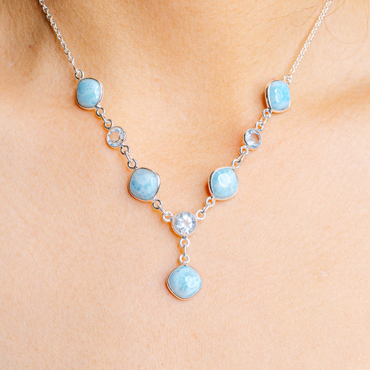 Sterling silver necklace with oval blue gemstones and small round clear accents