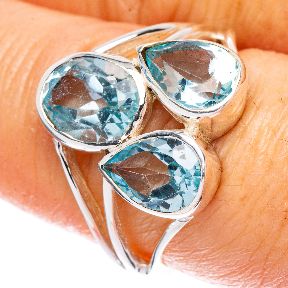 Sterling silver ring with three oval blue gemstone settings, prong-style topaz accents