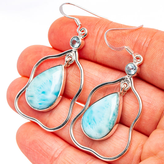 Silver teardrop earrings with light blue drop stones and small round blue accents
