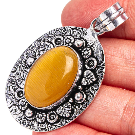 Silver filigree oval pendant with yellow cabochon and hanging bail, close-up