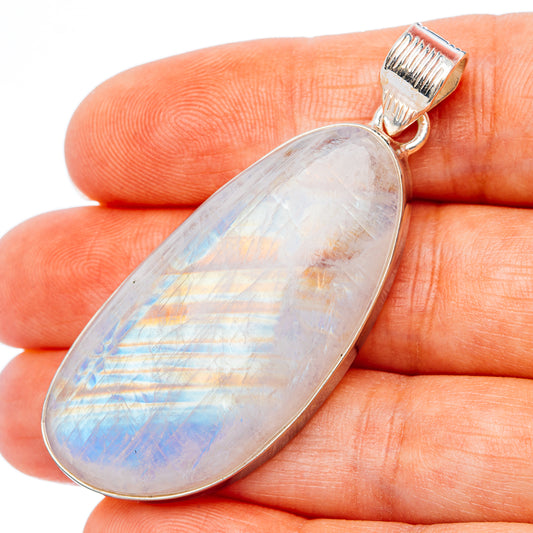 Large oval moonstone pendant, light iridescent flashes in silver bezel, on-finger closeup