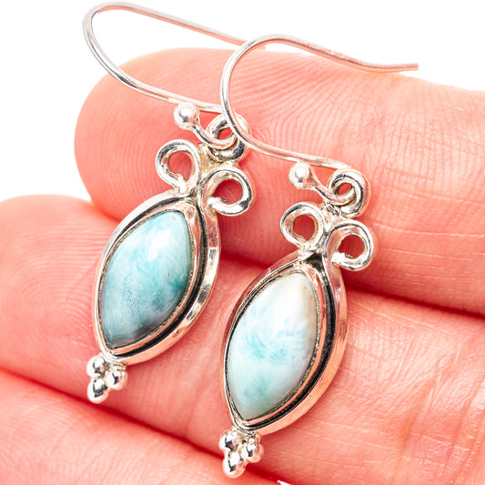 Sterling silver dangle earrings with oval blue larimar stones and heart details.