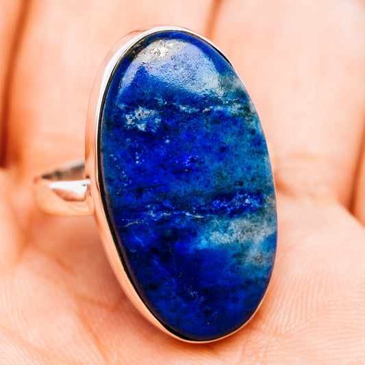 Oval blue gemstone ring in polished sterling silver bezel, side view.