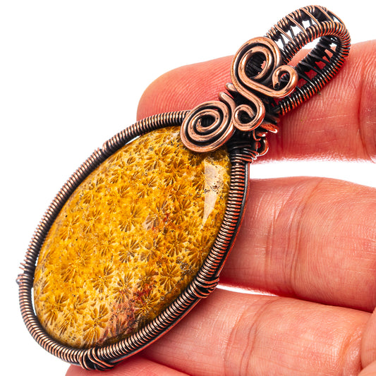 Oxidized copper wire-wrapped oval pendant with yellow fossil coral cabochon