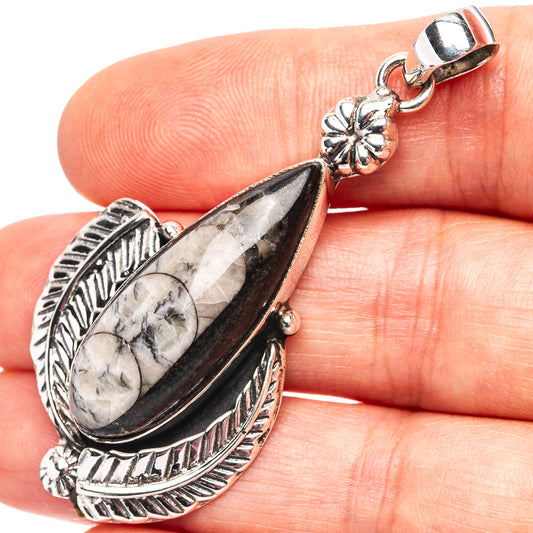 Sterling silver orthoceras fossil pendant close-up, oval fossil in etched bezel and bail
