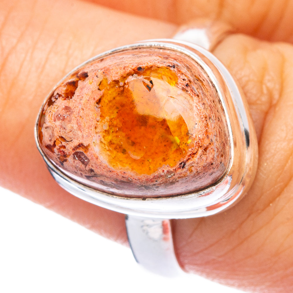 Sterling silver ring close-up of oval fire opal cabochon, warm orange with speckles