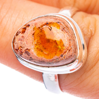 Sterling silver ring close-up of oval fire opal cabochon, warm orange with speckles