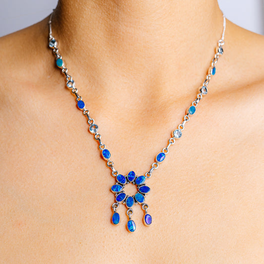 Sterling silver blue topaz necklace with oval gemstones and blue floral drop pendant
