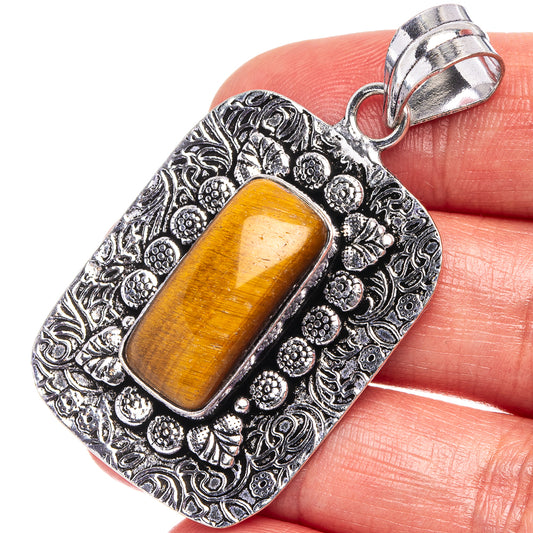 Tiger's eye pendant with orange tiger-eye cabochon in ornate silver-tone square bezel