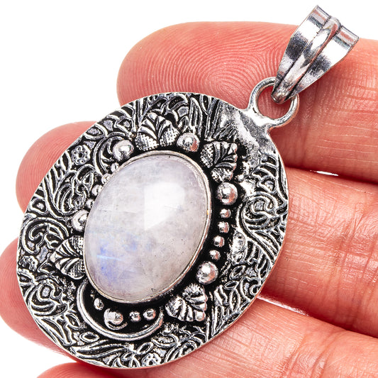 Oval moonstone cabochon pendant in ornate german silver frame, held in hand