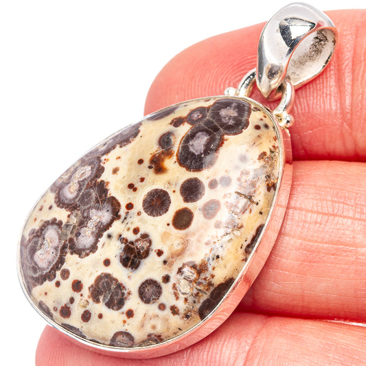 Sterling silver teardrop jasper pendant on hand, mottled cream and dark spots