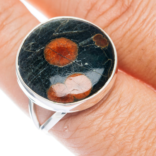 Sterling silver ring with dark obsidian cabochon and orange pebble-like inlays