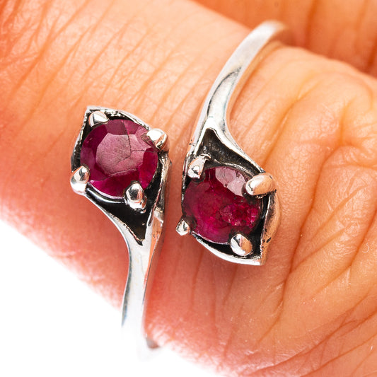 Sterling silver ring with two red faceted stones, close-up on hand