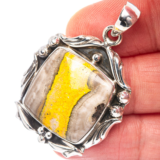 Sterling silver bumblebee jasper pendant in hand, rectangular yellow stone frame