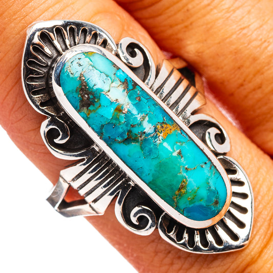 Closeup sterling silver turquoise oval ring on finger, ornate stamped shank
