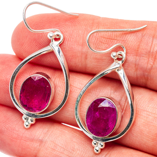 Sterling silver ruby drop earrings, close-up of round purple-red stones and teardrop frames