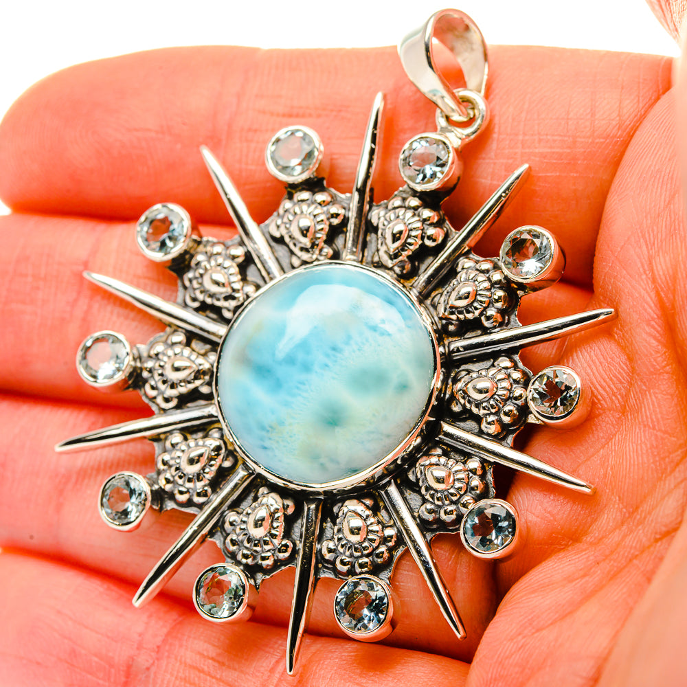 Sterling silver sunburst pendant with round blue cabochon and clear stone accents