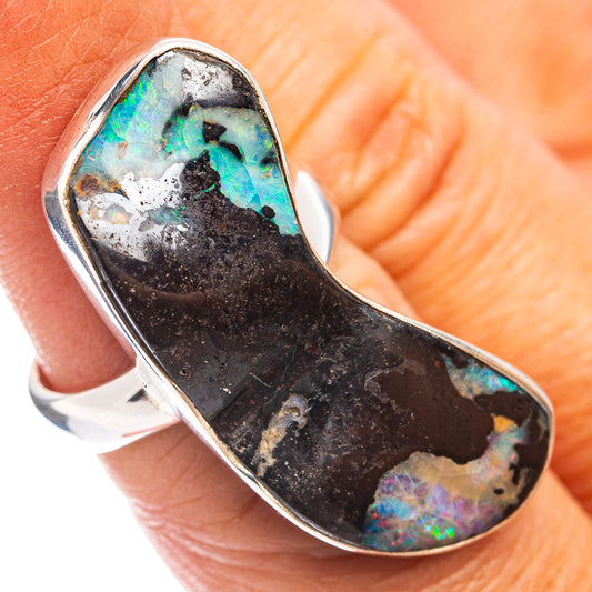 Sterling silver boulder opal ring with oval bezel, dark matrix and teal-blue flashes.