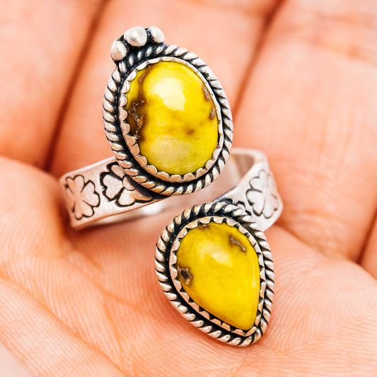Silver-tone ring with yellow oval cabochon, rope border, and cutout floral band