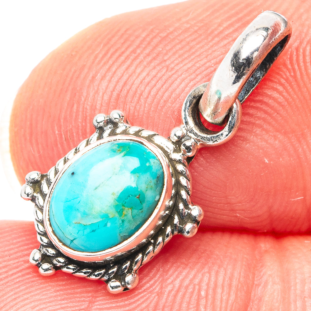 Oval turquoise cabochon sterling silver pendant with ornate bezel and hinged bail