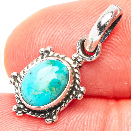 Oval turquoise cabochon sterling silver pendant with ornate bezel and hinged bail