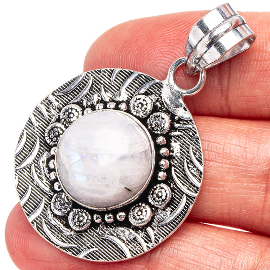 German silver moonstone pendant with round cabochon in ornate circular frame, bail on top.
