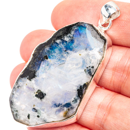 Raw rainbow moonstone pendant in silver bezel, rough stone with glowing blue flash