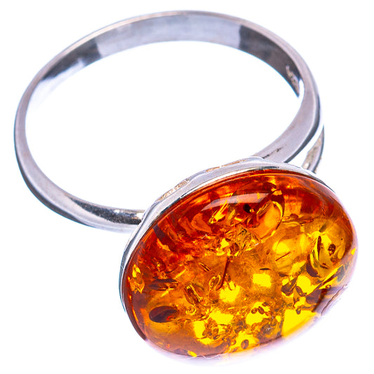 Adjustable sterling silver ring with oval amber cabochon in warm honey-orange tones