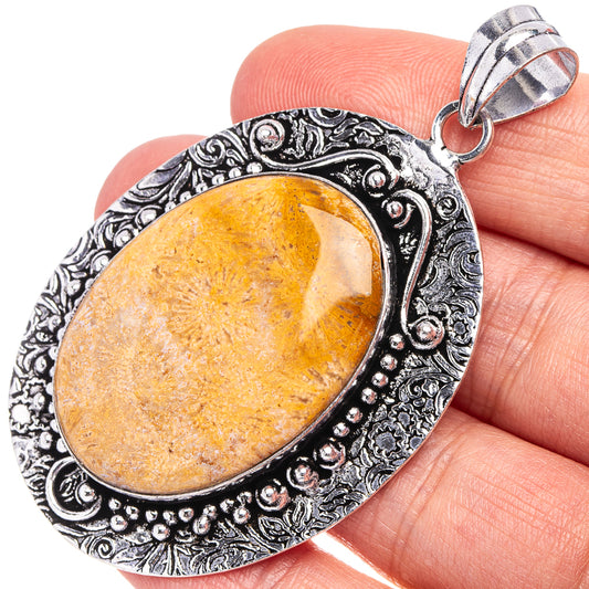 German silver coral pendant with oval orange cabochon in ornate filigree frame