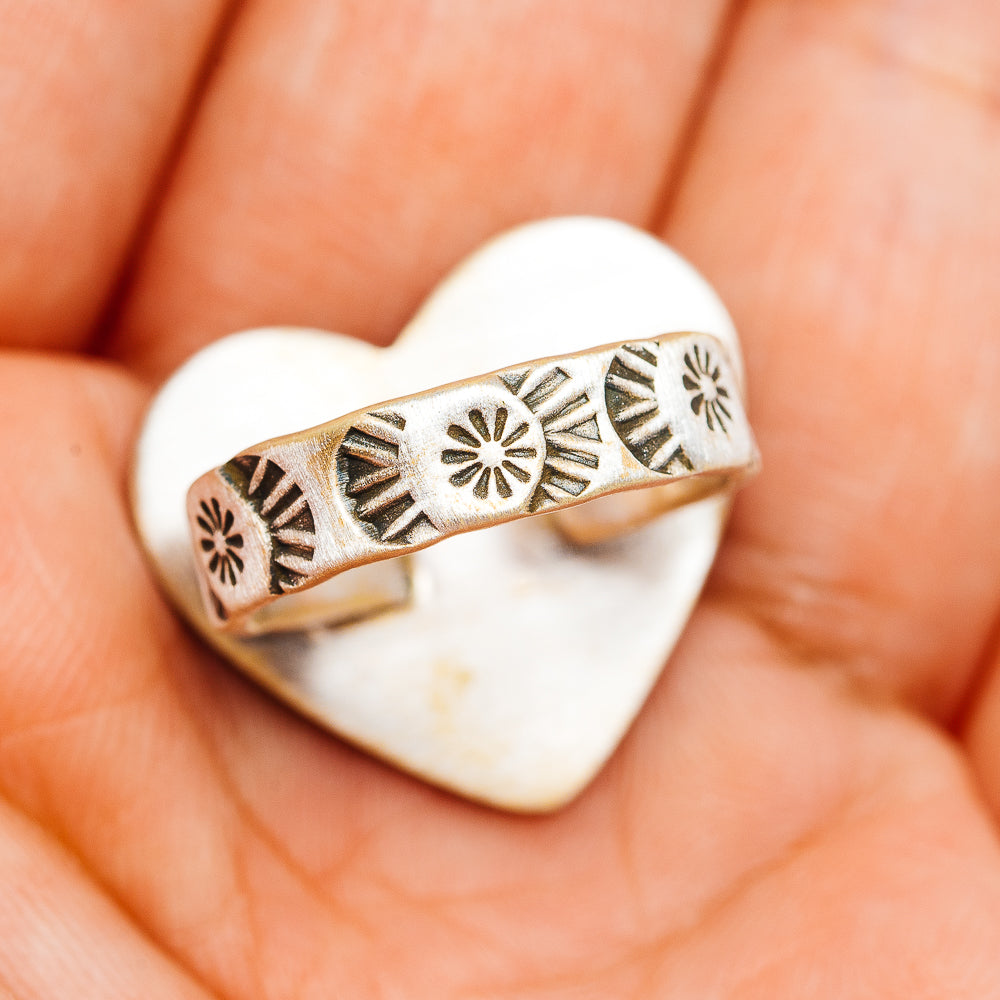 Silver-toned band ring with stamped geometric motifs and heart-shaped bezel window