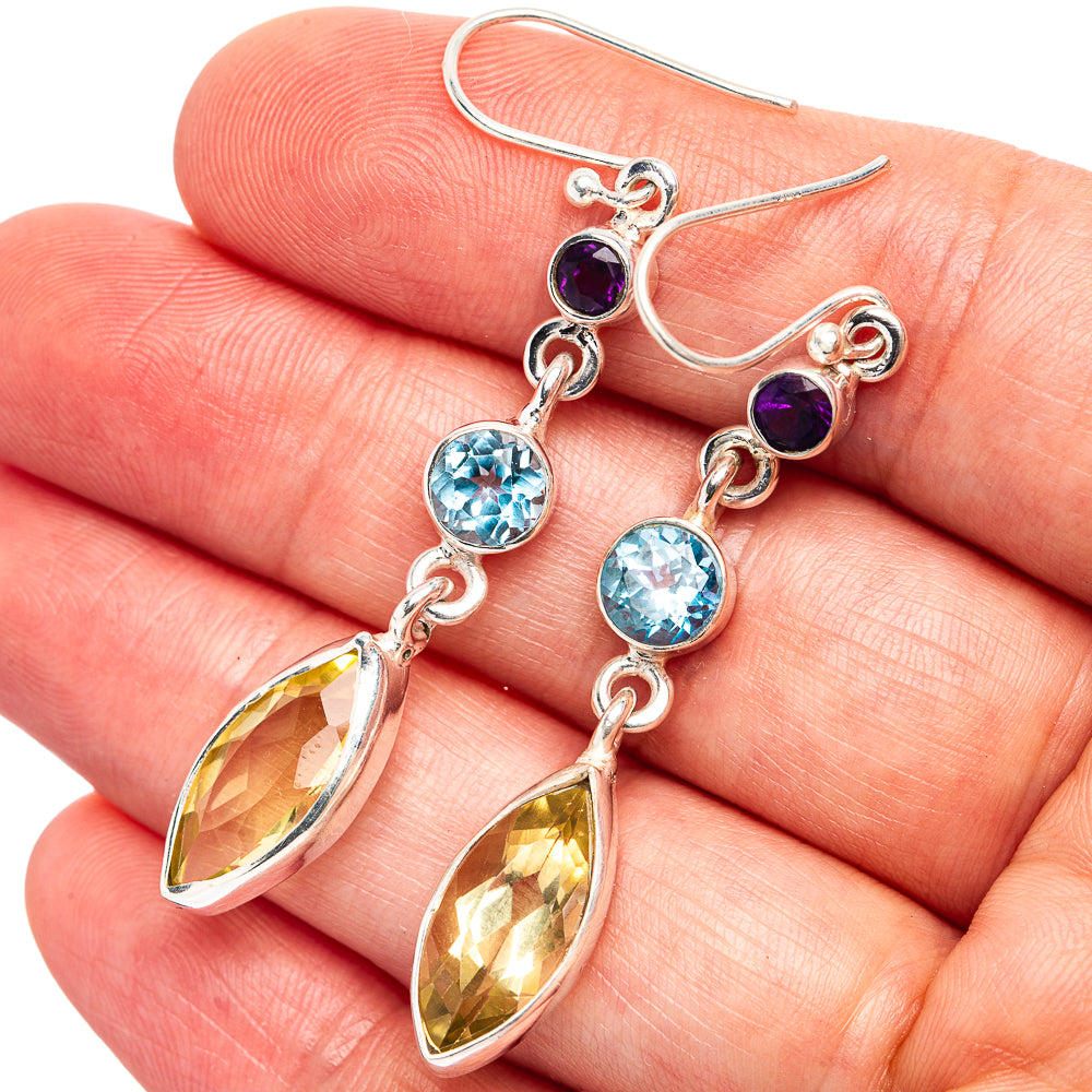 Sterling silver drop earrings with purple, blue, and yellow faceted gemstones