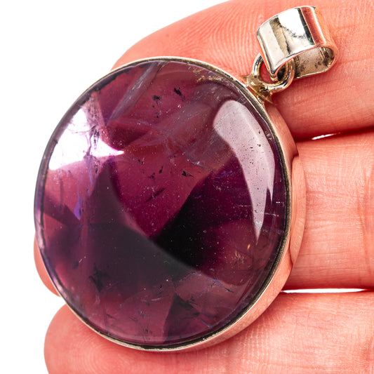 Oval amethyst pendant with star-like purple pattern and .925 sterling silver bezel
