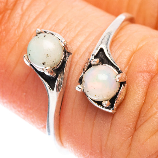 Dainty sterling silver ring with two light opal cabochons in openwork settings
