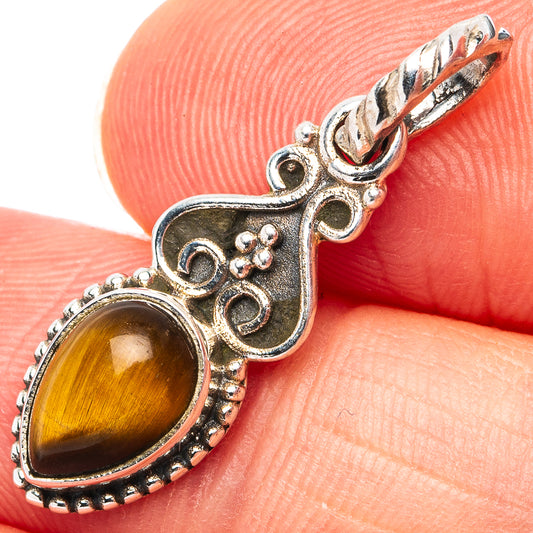 Tiger's eye pendant close-up, oval stone in ornate sterling silver frame