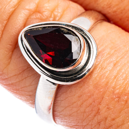 Sterling silver garnet ring with faceted oval gemstone, dark red center bezel